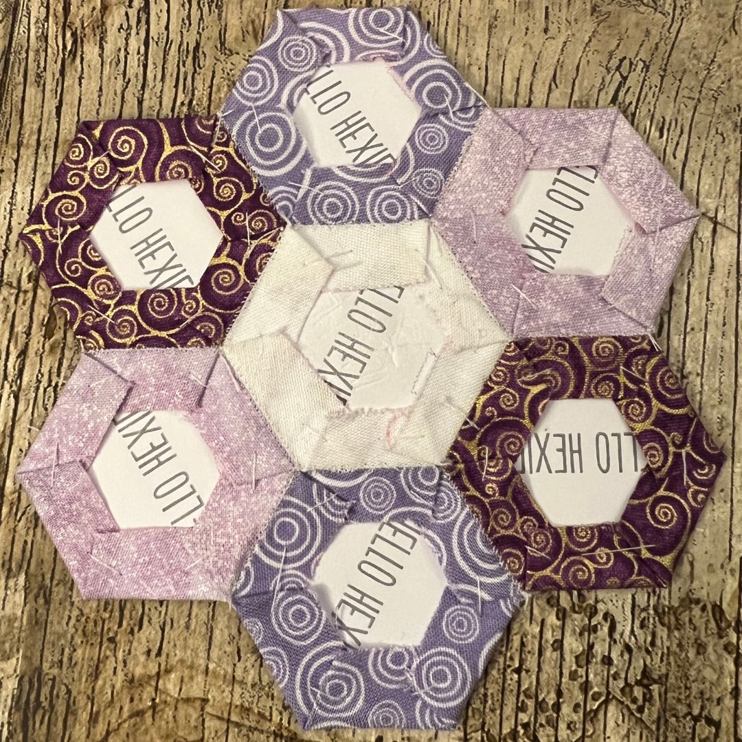 Hexagonal paper crafts with 'LOU HEXIE' branding on a wooden surface