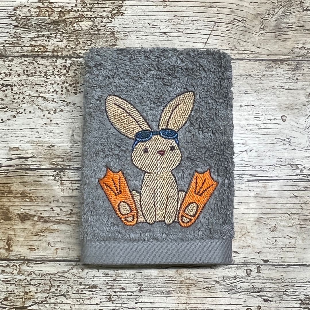 A rather cute brown little rabbit is all ready for the beach with their googles and flippers, This design can be embroidered onto face cloths to order at Coralie's Crafts & Gifts in Dorset