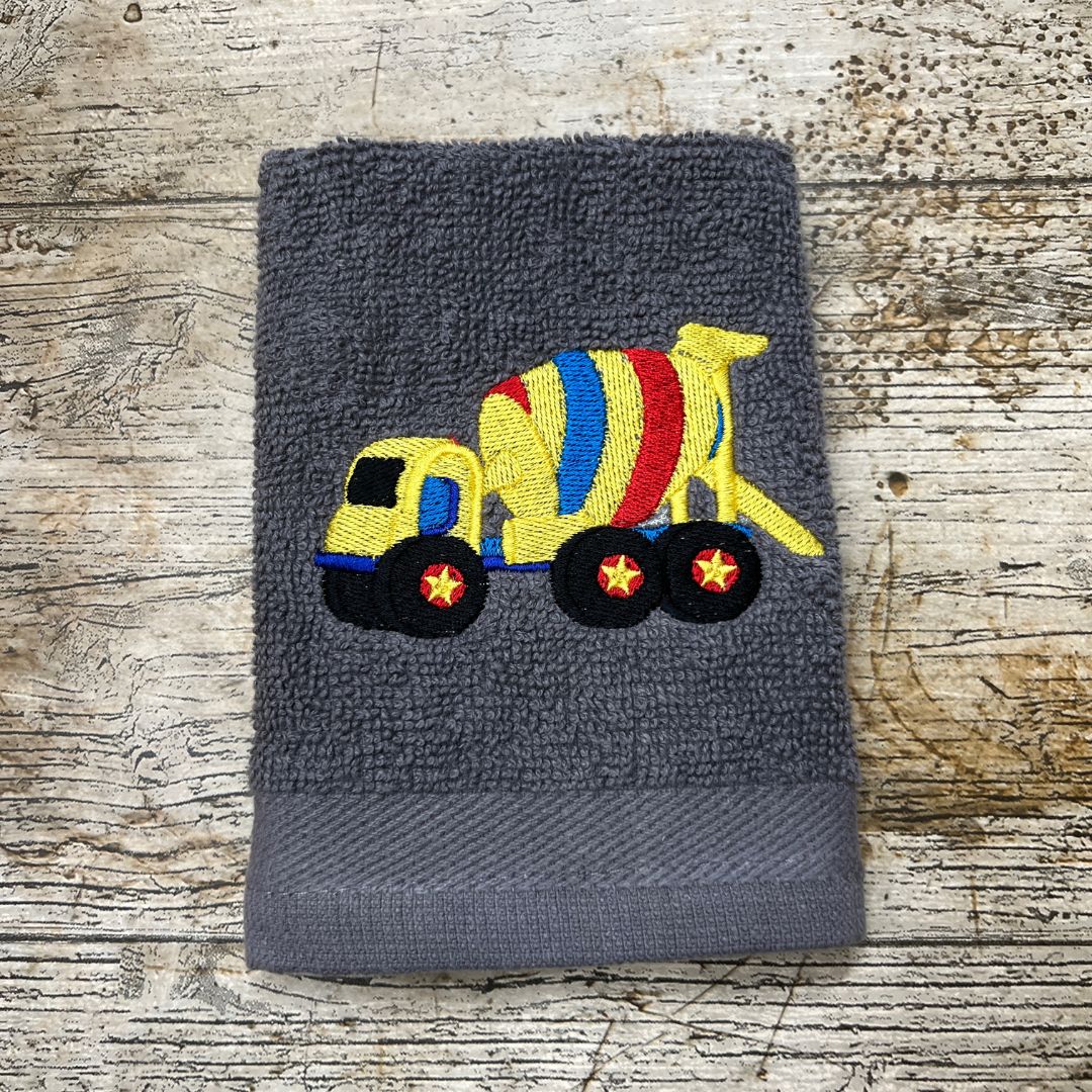 Fabulous Cement Mixer design embroidered on to a face cloth and placed on a wooden background, made by Coralie's Crafts & Gifts