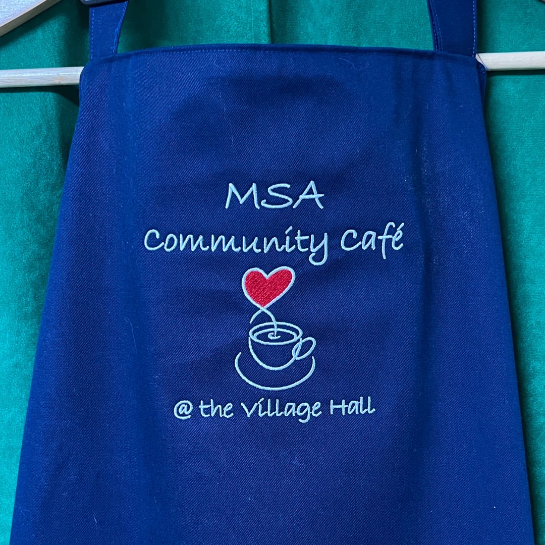 Blue Aprons with the MSA community cafe logo 