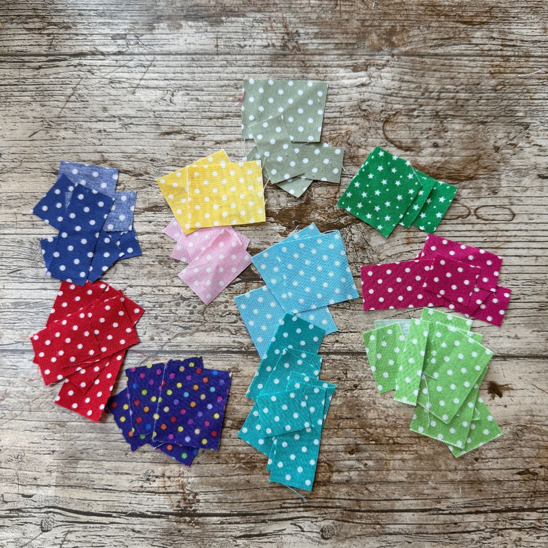 Colorful polka dot fabric squares on a wooden surface